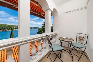 a balcony with chairs and a table and a view of the water at APARTMENTS JADRANKa in Omišalj +164 photos