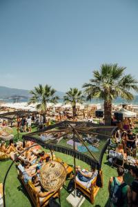 eine Gruppe von Menschen, die auf dem Gras an einem Strand liegen in der Unterkunft Thelxis in Volos