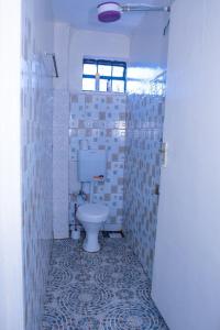 a bathroom with a toilet in a room with tiles at Micasa Homes BNB GF in Limuru