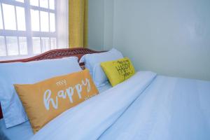 a bed with two pillows with the words fix happy at Micasa Homes BNB GF in Limuru