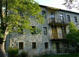 an old stone building with balconies and a tree at Villa Lila in Dolno Dupeni