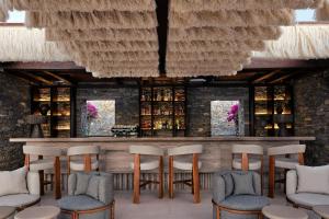 a bar in a restaurant with chairs and tables at Oroséa Paros - Adults Only, Autograph Collection in Naousa