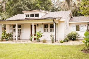 a white house with a lawn in front of it at Pigeon Point Cottage with State Park Beach Pass in Beaufort