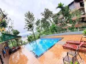 a swimming pool with two benches at Silver Green Resort in Wayanad