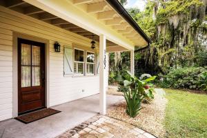 a front porch of a house with a wooden door at Pigeon Point Cottage with State Park Beach Pass in Beaufort