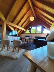 a living room with wooden ceilings and a table and chairs at L'insolite comblée in Ustou