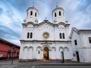 a large white church with two towers on a street at Suite Tarqui en el Centro Histórico in Cuenca