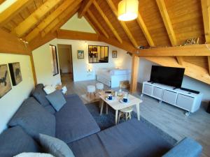 a living room with a couch and a table at L'insolite comblée in Ustou