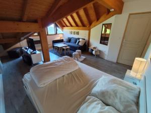 a bedroom with a bed and a living room at L'insolite comblée in Ustou