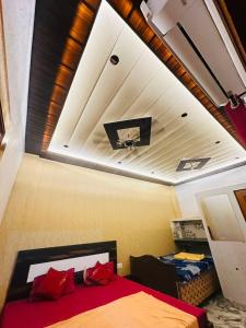 a bedroom with a ceiling with a tv and a bed at Lakshman Guest House Ayodhya in Jāmb +11 photos