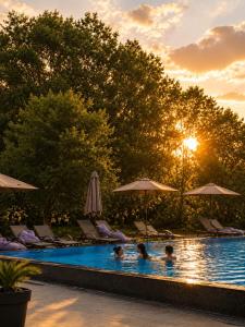 two people swimming in a swimming pool at sunset at Lula Apartments in Ulcinj +15 photos