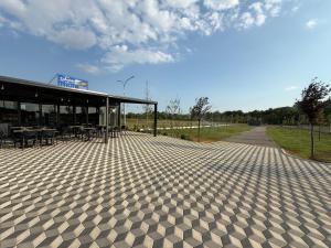 a building with a patio with tables and chairs at LakeSide Camping in Koplik