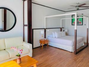 a bedroom with a bed and a couch and a mirror at Ocean Blue & Sand Beach Resort - All Inclusive in Punta Cana