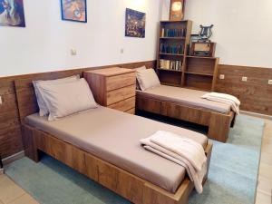 two beds in a room with a book shelf at Apartments Alexandra in Pleven