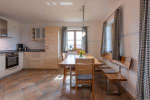 a kitchen and dining room with a table and chairs at Kramerhof - Ferienwohnung Zugspitze in Aufhofen