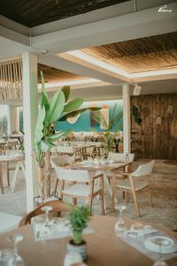 ein Restaurant mit weißen Tischen und Stühlen und einer Decke in der Unterkunft Thelxis in Volos