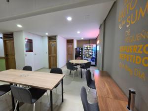 a restaurant with tables and chairs and a sign on the wall at Hotel Portal Central in Medellín