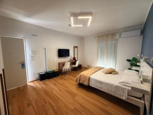 a bedroom with a bed and a desk and a television at Palazzo del Toro 2 in Montesilvano