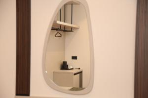 a mirror in a room with a table and a shelf at Terminal Hotel in Krujë