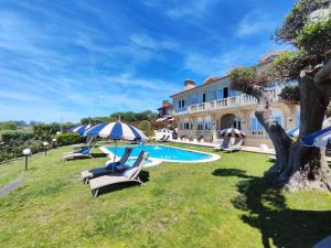 a villa with a swimming pool and a house at Suite atlántica in Oya