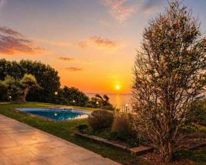 a sunset over the water with a swimming pool at Suite Marina Gallega in Oya