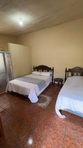 a bedroom with two beds and a tiled floor at Accommodation #6 in Copán Ruinas in Copán Ruinas