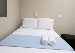 a bedroom with a bed with towels on it at Pousada Aurora Nascer do sol 1 in Manhã