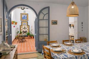 a dining room with a table and an archway at La Casa de la Punta in San Pol de Mar