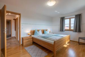 a bedroom with a large bed with blue pillows at Kramerhof - Ferienwohnung Zugspitze in Aufhofen