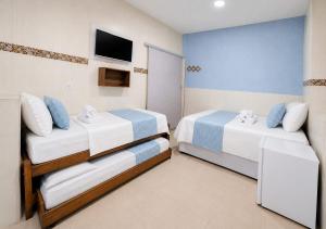 a room with two beds and a television in it at Pousada Aurora Nascer do sol 1 in Manhã