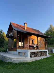 a log cabin with a porch and a table and chairs at Vila Vlasinski mir in Surdulica +11 photos