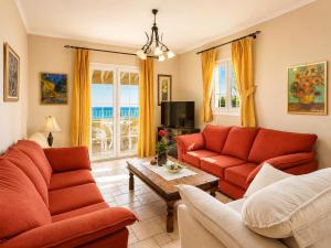 a living room with red couches and a table at Ioannas House in Nisaki