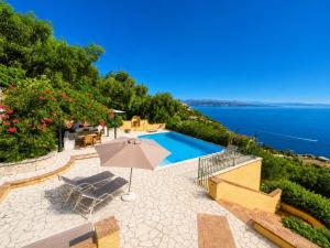 a patio with an umbrella and a swimming pool at Ioannas House in Nisaki