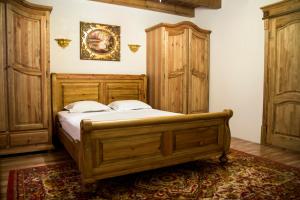 a bedroom with a wooden bed and a wooden cabinet at Usadba Bogach in Kobryn