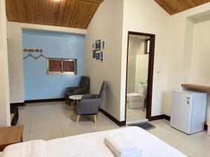 a room with a bed and a table and a bathroom at 好馨情民宿 in Nangan