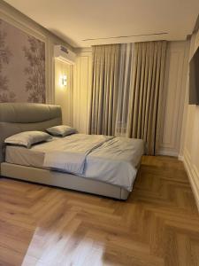 a bedroom with a bed and a large window at NRG BI Sado in Katartal