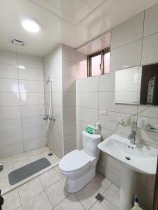 a white bathroom with a toilet and a sink at 好馨情民宿 in Nangan