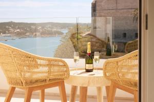 a table with a bottle of wine and two glasses at Catalonia Mirador des Port in Mahón