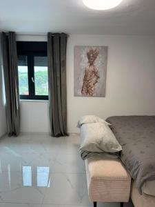 a bedroom with a bed and a picture on the wall at Plitvice House Lina in Rakovica +58 photos