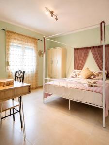 a bedroom with a canopy bed and a desk at Goldtown House in Chrysoupolis