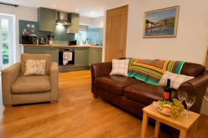 a living room with a couch and a chair at Newton Cottage South in Inveraray