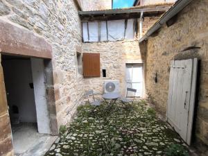 an alley with a table and chairs in a building at Le Cocon de Sévérac I Clim & cour intérieure in Sévérac d' Aveyron