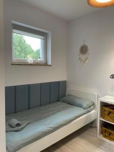 a bed in a room with a window at Sosnowy Zakątek in Radęcin