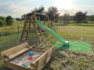 a playground with a slide in a field at Sosnowy Zakątek in Radęcin
