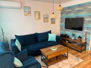 a living room with a blue couch and a tv at Apartament Color4you Blue in Wschowa