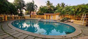 a swimming pool in front of a house at Tripo bay inn in Mahabalipuram