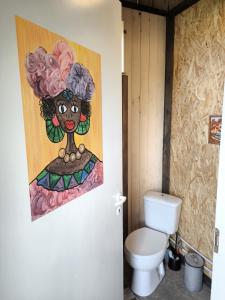 a bathroom with a painting on the wall next to a toilet at Sauna Suite 2 in Valga