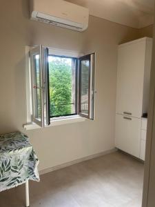 an empty room with a window and a refrigerator at San Leo Apartment in Stia +1 photo