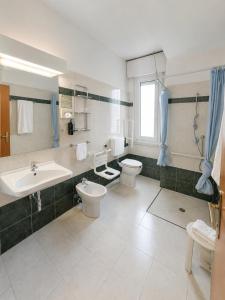 a bathroom with two toilets and a sink at Hotel Italia in Ravenna