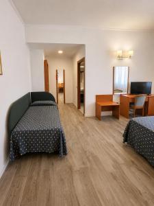 a hotel room with two beds and a dining room at Hotel Italia in Ravenna